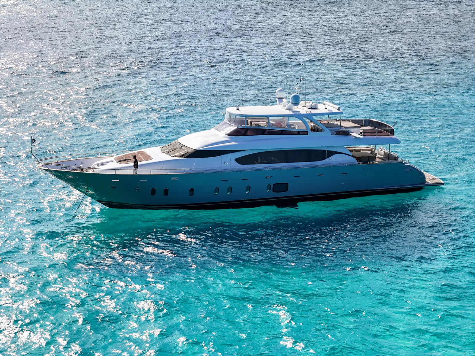 A motor yacht at anchor in clear turquoise water