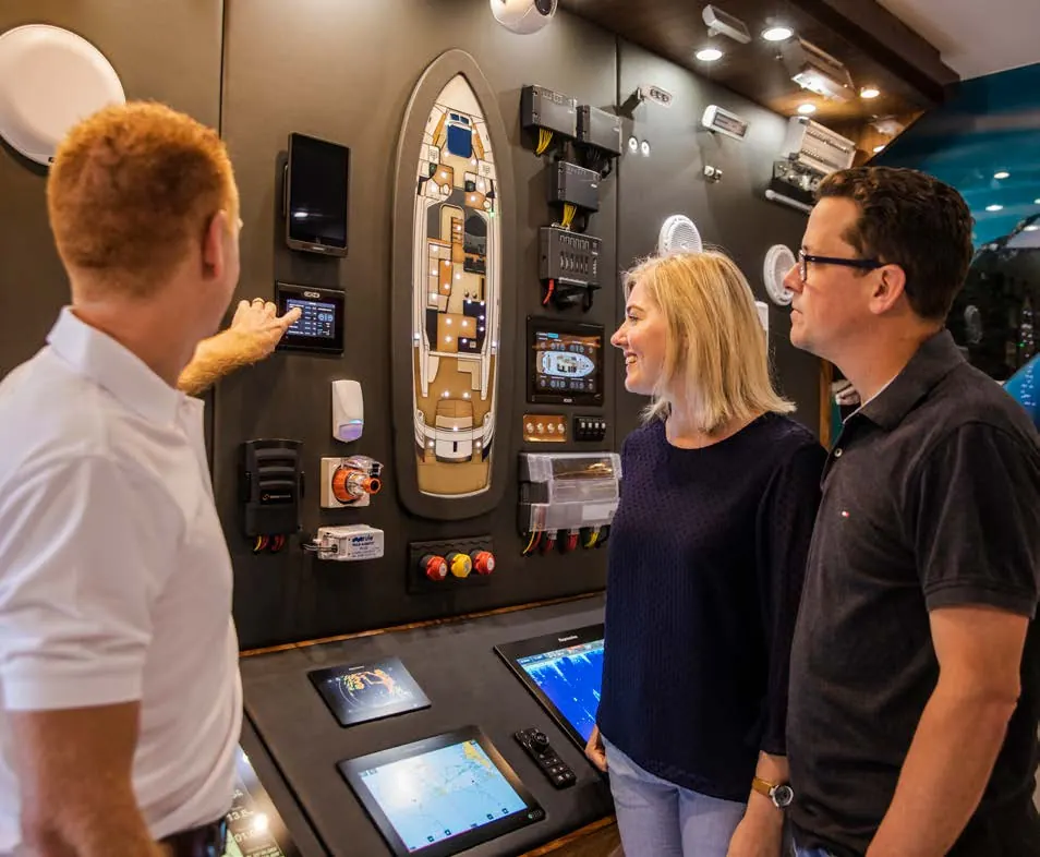 A Riviera specialist demonstrating a marine electronics display to a couple