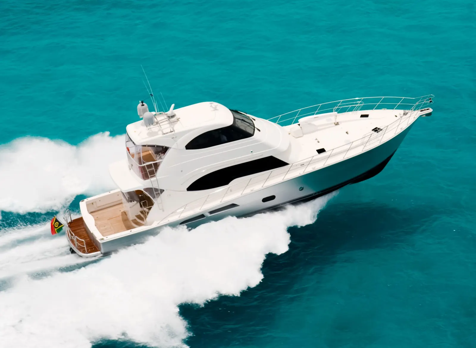 A Riviera flybridge motor yacht running on turquoise water